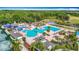 An aerial view showcases a community pool, clubhouse, and surrounding greenery at 4207 Fishermans Lake Dr, Lutz, FL 33558