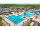 An aerial view features a community pool, sun loungers, and lush landscaping at 4207 Fishermans Lake Dr, Lutz, FL 33558