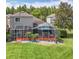 A view of the screened in lanai with lounge furniture surrounded by lush landscaping at 4207 Fishermans Lake Dr, Lutz, FL 33558