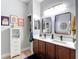 Double sink bathroom features a wood cabinet, and bright light fixture at 4207 Fishermans Lake Dr, Lutz, FL 33558
