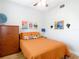 Bright bedroom featuring a queen bed, wooden dresser, and stylish artwork at 4207 Fishermans Lake Dr, Lutz, FL 33558