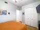 Neutral toned bedroom with closet and orange bedding at 4207 Fishermans Lake Dr, Lutz, FL 33558