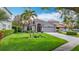 Beautiful single-story home featuring lush landscaping, a spacious two-car garage, and a well-maintained lawn at 4207 Fishermans Lake Dr, Lutz, FL 33558