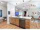 Open-concept kitchen island with wooden cabinetry, stainless steel appliances, and modern pendant lighting at 4207 Fishermans Lake Dr, Lutz, FL 33558