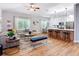 Bright open-concept living space showcasing hardwood floors and modern furniture with a view of the kitchen at 4207 Fishermans Lake Dr, Lutz, FL 33558