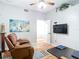 A modern office space with a ceiling fan, television, and comfortable leather chair at 4207 Fishermans Lake Dr, Lutz, FL 33558