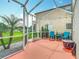 Picturesque screened-in patio with colorful string lights and a view of lush landscaping at 4207 Fishermans Lake Dr, Lutz, FL 33558
