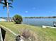 Serene backyard overlooking the water, framed by lush greenery and a clear blue sky at 4333 Baden Dr, Holiday, FL 34691