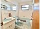 Retro bathroom with a blue toilet, sink, and tub, complemented by classic white and blue wall tiles at 4333 Baden Dr, Holiday, FL 34691
