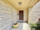 Inviting front porch with a brick exterior, a charming wooden door, and neatly trimmed landscaping at 4333 Baden Dr, Holiday, FL 34691