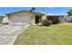Charming single-story home featuring an attached garage and a well-maintained lawn with attractive landscaping at 4333 Baden Dr, Holiday, FL 34691