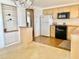 Traditional kitchen with light wood cabinets, white appliances, and built-in shelving unit at 4333 Baden Dr, Holiday, FL 34691