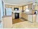 Bright kitchen features wood cabinets, black appliances, and a window above the sink for natural lighting at 4333 Baden Dr, Holiday, FL 34691