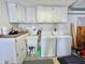 Well-lit laundry room with washer, dryer, utility sink, and storage cabinets at 4333 Baden Dr, Holiday, FL 34691