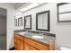 Bathroom featuring a double sink vanity with granite countertop and framed mirrors at 4369 Marine Pkwy, New Port Richey, FL 34652