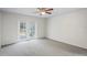 Sunlit bedroom with plush carpet and access to outdoor patio through double doors at 4369 Marine Pkwy, New Port Richey, FL 34652