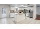 Bright kitchen with white cabinets, granite countertops, stainless appliances, and large island at 4369 Marine Pkwy, New Port Richey, FL 34652