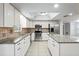 Bright kitchen featuring white cabinetry, tile backsplash, stainless appliances, and large island at 4369 Marine Pkwy, New Port Richey, FL 34652