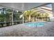 Inviting in-ground pool is surrounded by a screened enclosure with a brick-paved patio at 4369 Marine Pkwy, New Port Richey, FL 34652