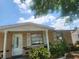 Charming home exterior featuring a covered porch, tan siding, and manicured landscaping at 4534 Irene Loop, New Port Richey, FL 34652