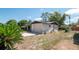 View of the rear of the home and one-car garage on a sunny day with blue skies at 5018 Sherwood Dr, New Port Richey, FL 34652