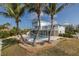 Stunning exterior view of a two-story light blue waterfront home with a pool and palm trees at 5040 Waterside Dr, Port Richey, FL 34668