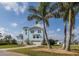 Inviting two-story home with attached garage, lush landscaping, and towering palm trees at 5040 Waterside Dr, Port Richey, FL 34668