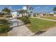 Charming light blue waterfront home featuring lush landscaping, a metal roof, and plenty of curb appeal at 5040 Waterside Dr, Port Richey, FL 34668