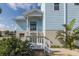 Inviting front porch with white railings, complemented by lush tropical landscaping at 5040 Waterside Dr, Port Richey, FL 34668