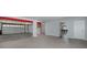 View of a large garage with high ceilings, white door and visible red support beams at 5040 Waterside Dr, Port Richey, FL 34668