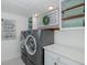 Laundry room with front load washer and dryer, storage cabinets and shelving at 5040 Waterside Dr, Port Richey, FL 34668