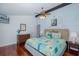 Relaxing main bedroom featuring cherry wood floors, a ceiling fan, and a decorative bedspread with beach-themed decor at 5040 Waterside Dr, Port Richey, FL 34668
