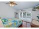 Comfortable main bedroom featuring wood floors, a ceiling fan, a large window, and a decorative bedspread at 5040 Waterside Dr, Port Richey, FL 34668