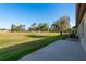 Large backyard with lush green grass, blue skies, and view of the golf course at 5931 Precious View Ct, New Port Richey, FL 34655