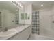 Bathroom featuring a double sink vanity, large mirror, and shower-tub combo with striped shower curtain at 5931 Precious View Ct, New Port Richey, FL 34655