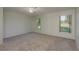 Spacious bedroom with neutral carpet and two bright windows with outdoor views at 5931 Precious View Ct, New Port Richey, FL 34655