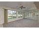 Bright living room with large windows showcasing green outdoor views and a wall mirror at 5931 Precious View Ct, New Port Richey, FL 34655