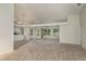 The expansive living room has large windows that bring in natural light and new carpet flooring at 5931 Precious View Ct, New Port Richey, FL 34655