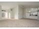 An open-concept living room and kitchen area boasts abundant natural light and plush carpeting at 5931 Precious View Ct, New Port Richey, FL 34655