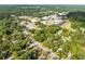 An eye-level aerial view highlights the mature tree coverage, quiet neighborhood, and proximity to nearby schools and businesses at 606 Howell Ave, Brooksville, FL 34601