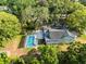 Beautiful aerial view of home with a screened-in pool, surrounded by mature trees at 606 Howell Ave, Brooksville, FL 34601