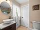 Well-lit bathroom with a modern sink, oval mirror, and tiled floors at 606 Howell Ave, Brooksville, FL 34601