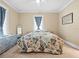 Comfortable bedroom with a floral-patterned bedspread, soft carpet, and natural light from the window at 606 Howell Ave, Brooksville, FL 34601