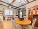 Open dining area with a round table, wooden hutch, and decorative ceiling beams at 606 Howell Ave, Brooksville, FL 34601