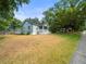 Charming home with a well-maintained lawn and mature trees, complemented by the sidewalk and street at 606 Howell Ave, Brooksville, FL 34601