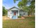 Charming single-Gathering home with a red front door, a quaint porch and vibrant landscaping at 606 Howell Ave, Brooksville, FL 34601