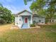 Charming home featuring a classic front porch, complemented by well-maintained landscaping and a vibrant red front door at 606 Howell Ave, Brooksville, FL 34601