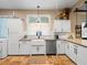 Clean white kitchen with stainless steel appliances, farmhouse sink, and ample storage at 606 Howell Ave, Brooksville, FL 34601