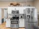 Kitchen with stainless steel appliances, white cabinets, subway tile, granite countertops and a decorative display shelf at 606 Howell Ave, Brooksville, FL 34601