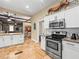 View of the kitchen featuring stainless steel appliances, white cabinets and access to the dining area at 606 Howell Ave, Brooksville, FL 34601